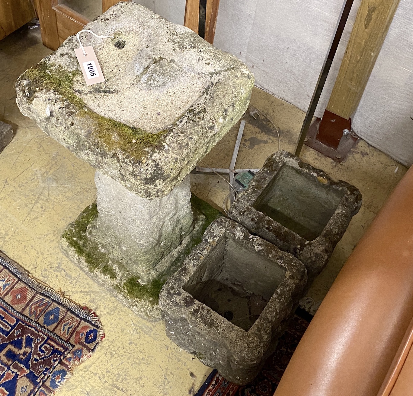 A pebble effect reconstituted stone bird bath, height 67cm together with two similar smaller square planters